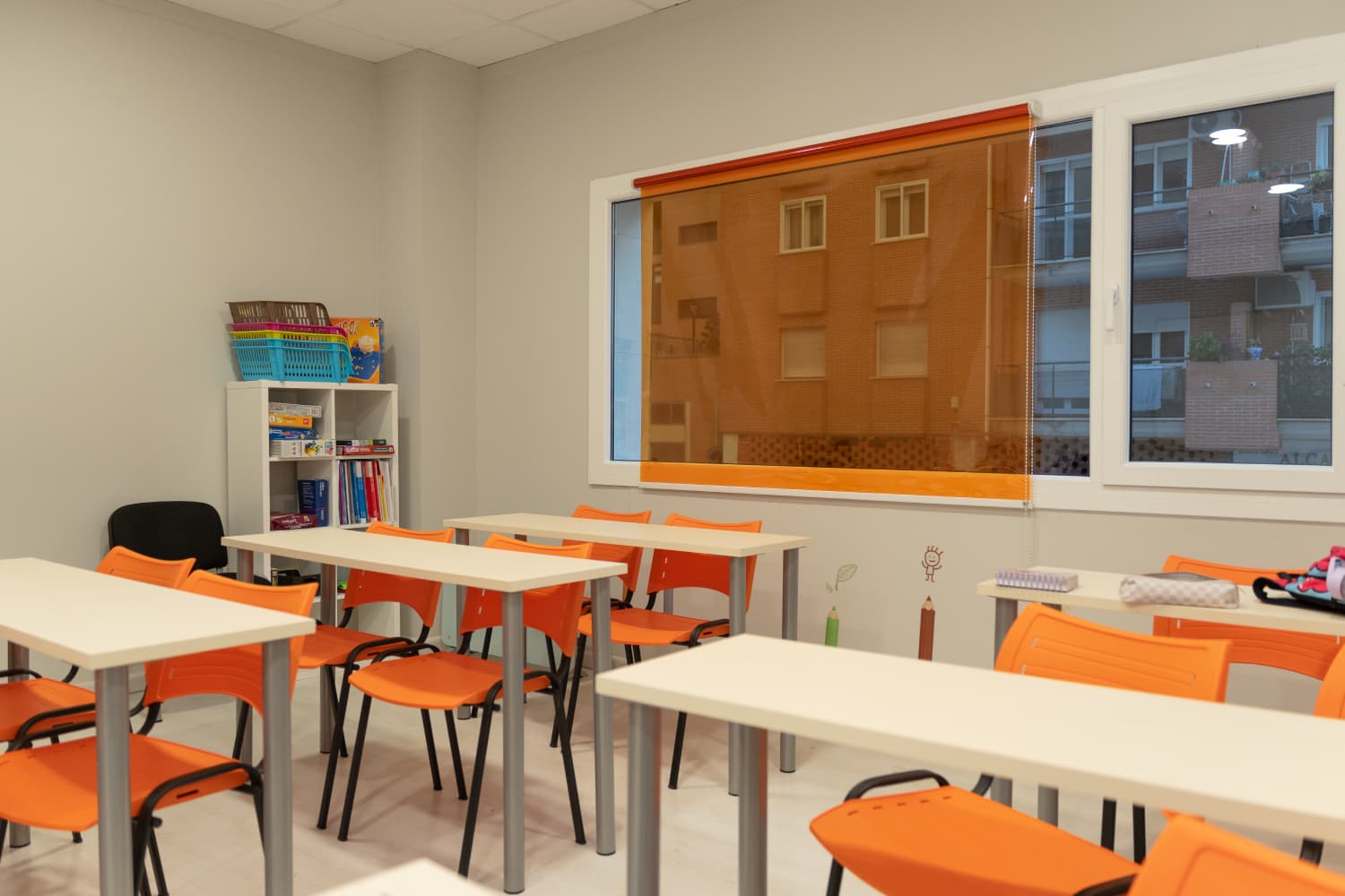 Clase luminosa con pupitres individuales y material listo para el alumnado