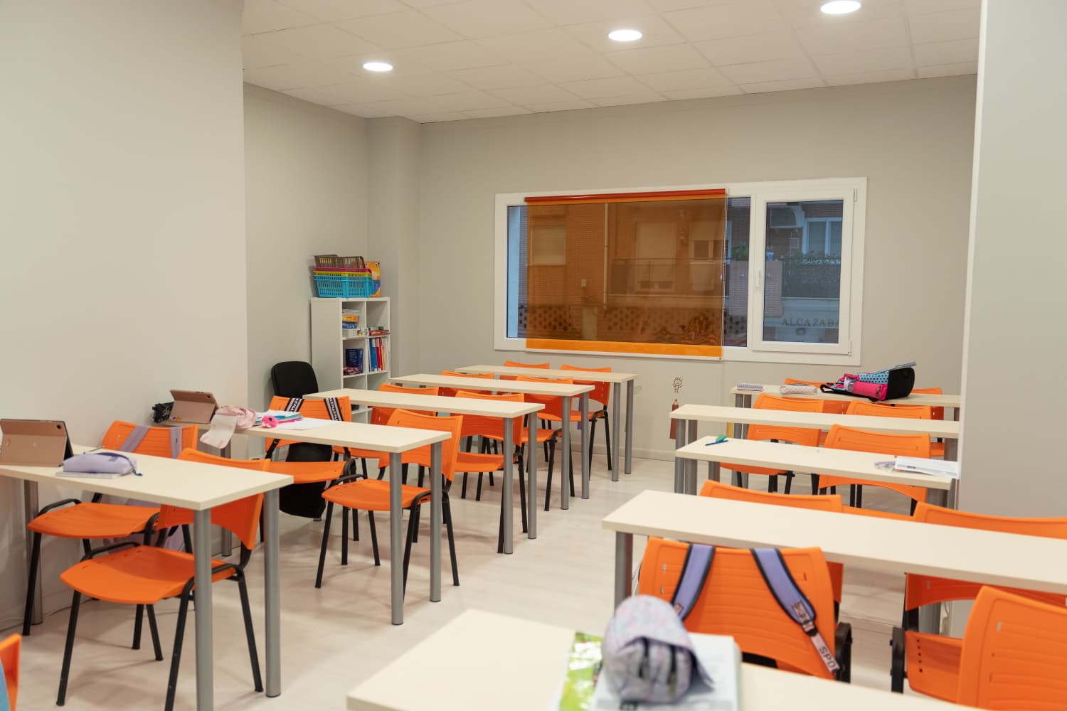 Espacio de aula con proyector, pizarra blanca y distribución cómoda para grupos