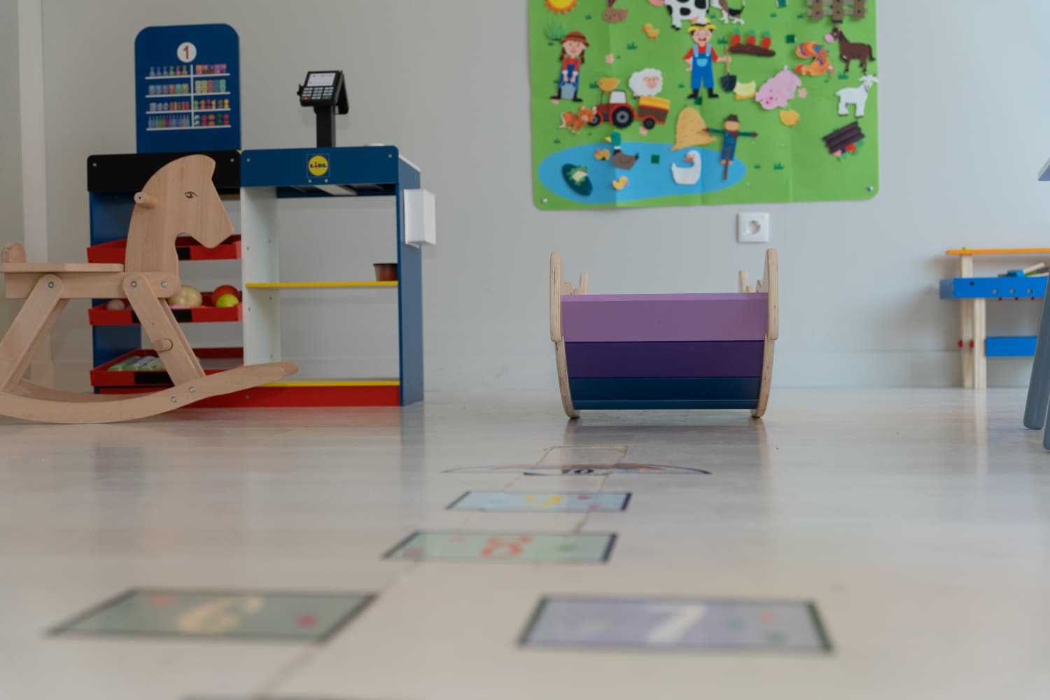 Espacio infantil con mesas, sillas pequeñas y recursos para aprender jugando