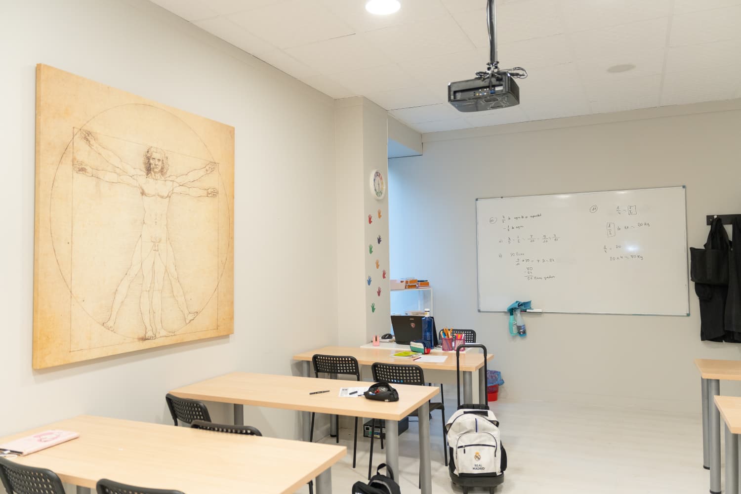Clase del centro con mesas de trabajo, pared decorada y espacio cómodo para aprender